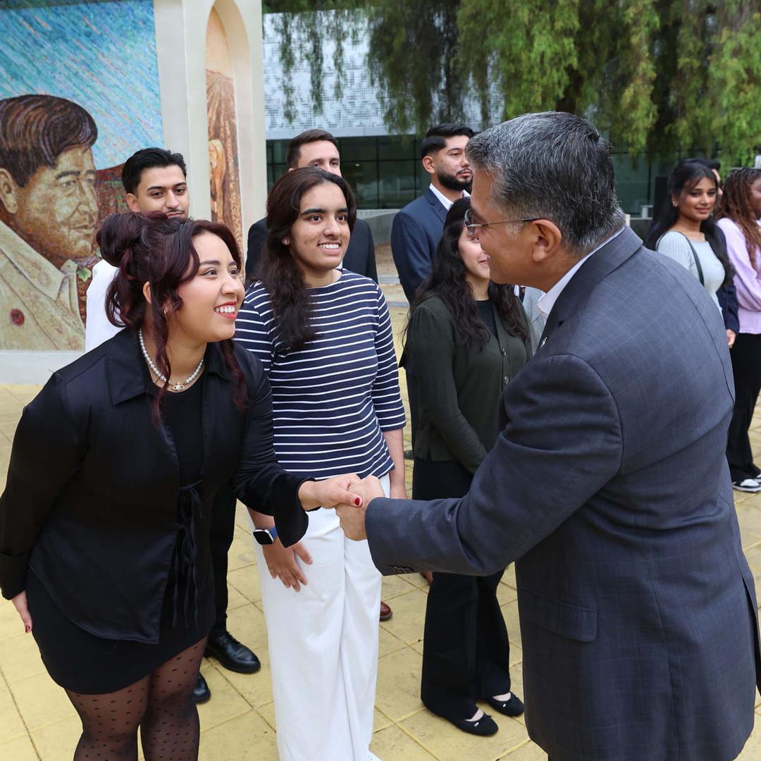 U.S. Secretary of Health and Human Services (HHS) Xavier Becerra shakes hands with Katy Reyes, ‘26 Aviation, during a recent visit to 菠菜网lol正规平台. Photo by David G. 麦金太尔.